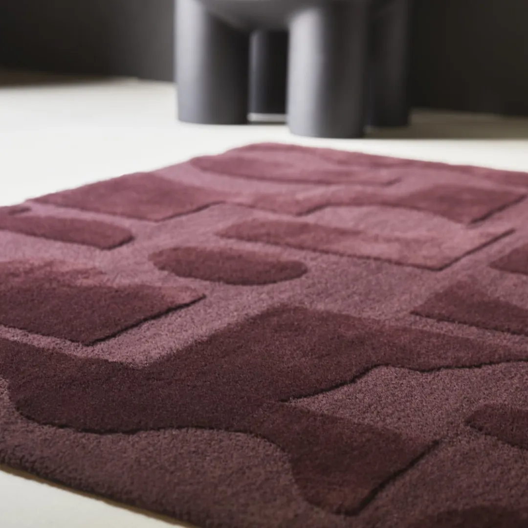 Stylish geometric rug featuring abstract forms in a deep maroon color.