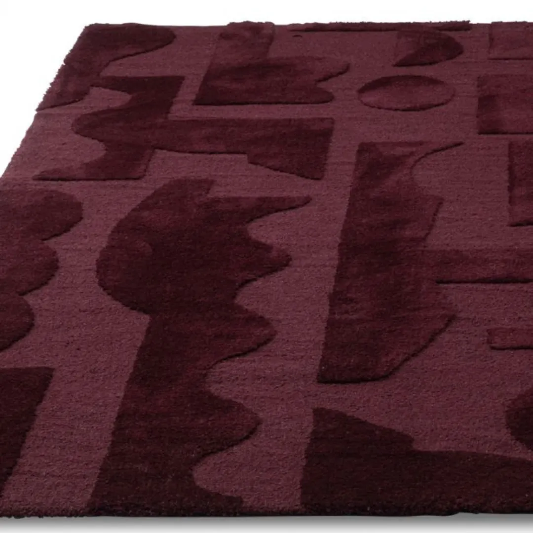 Modern abstract area rug with bold shapes and maroon tones.