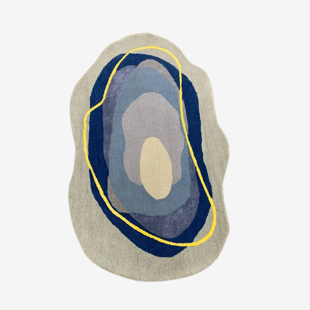 Abstract organic-shaped rug with blue, purple, gray, and yellow tones.
