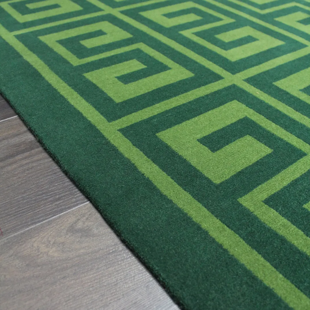 Elegant green area rug with repeating Greek key pattern.