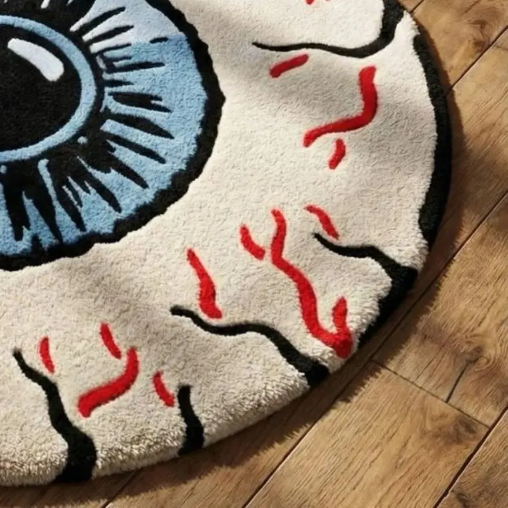 Blood Eye Rug Texture Close up shot of the Blood Eye hand tufted rug showing the detailed blue iris, black pupil, and red vein patterns.