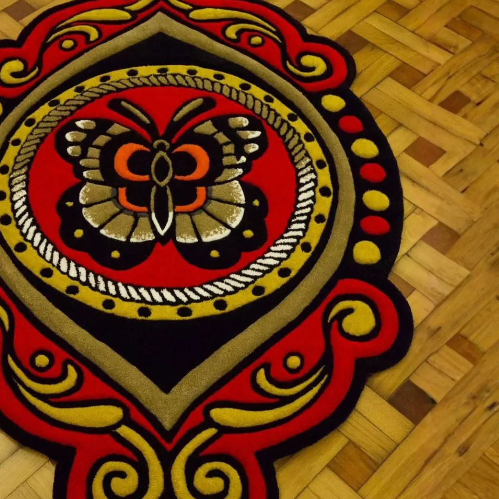 Ember Mane Hand Tufted Rug Ornate Border Texture Close up texture detail of the Ember Mane rug showing the ornate red and gold scrollwork on the scalloped edge.