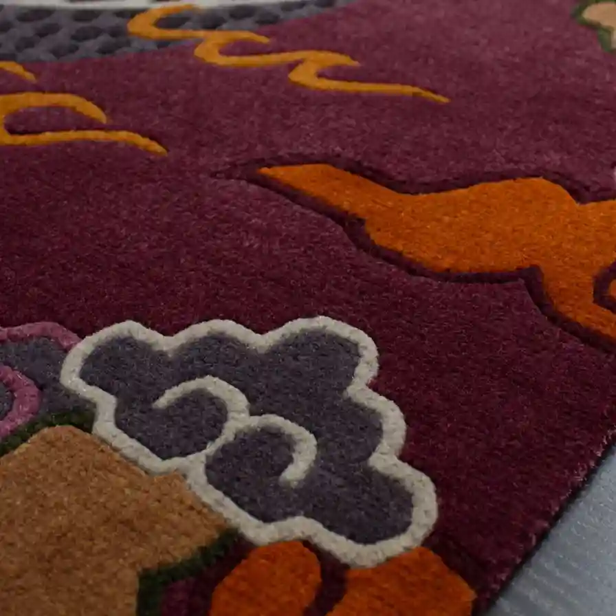 Crimson Omen Rug Wool Texture Detail Extreme close up of the hand tufted wool texture on the Crimson Omen rug, focusing on the dense cut pile of the purple background and the precise carving of the cloud borders.