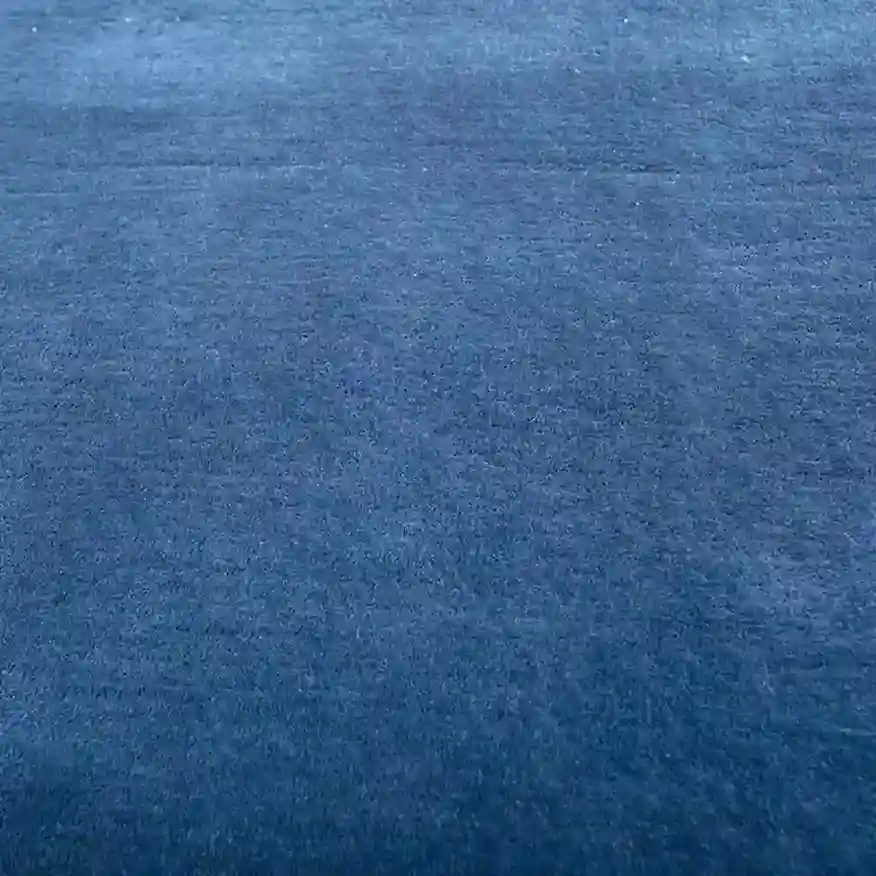 Cera Performance Solid Blue Area Rug in minimalist design for living room.