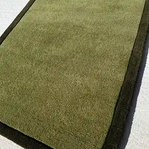 minimalist olive rug styled with wood furniture