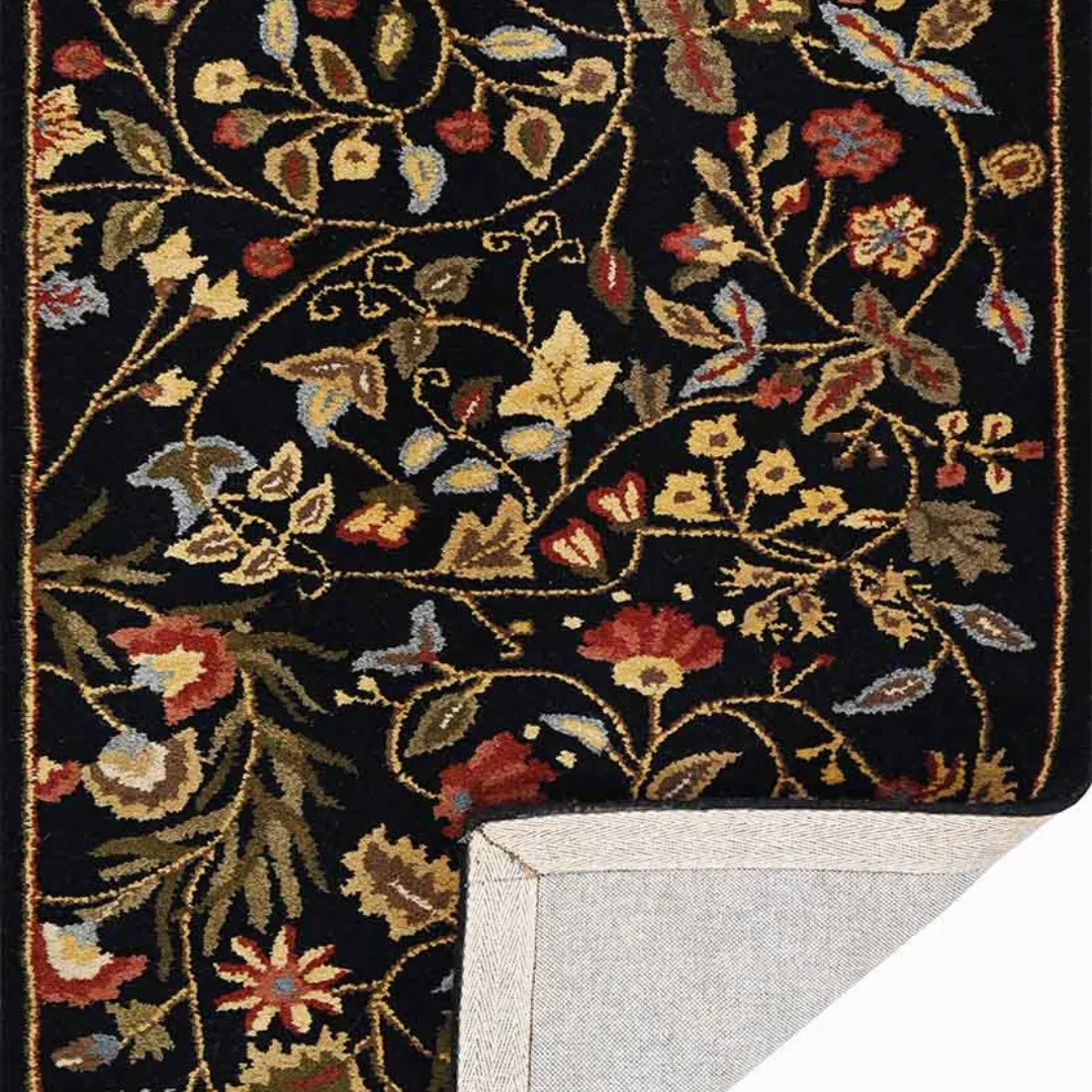 Wool floral rug with red, green, and gold accents on dark background