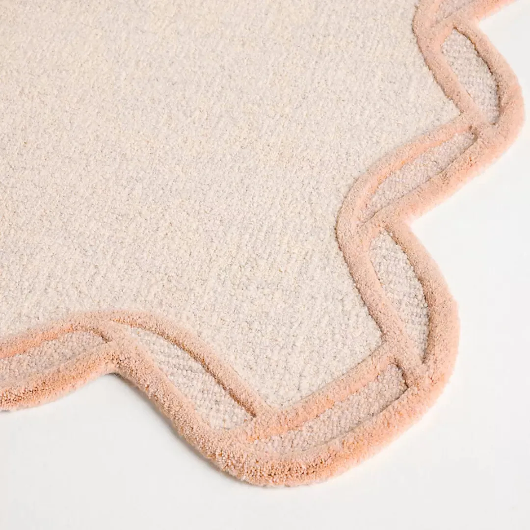 Top-down view of orange hand tufted rug with soft edges