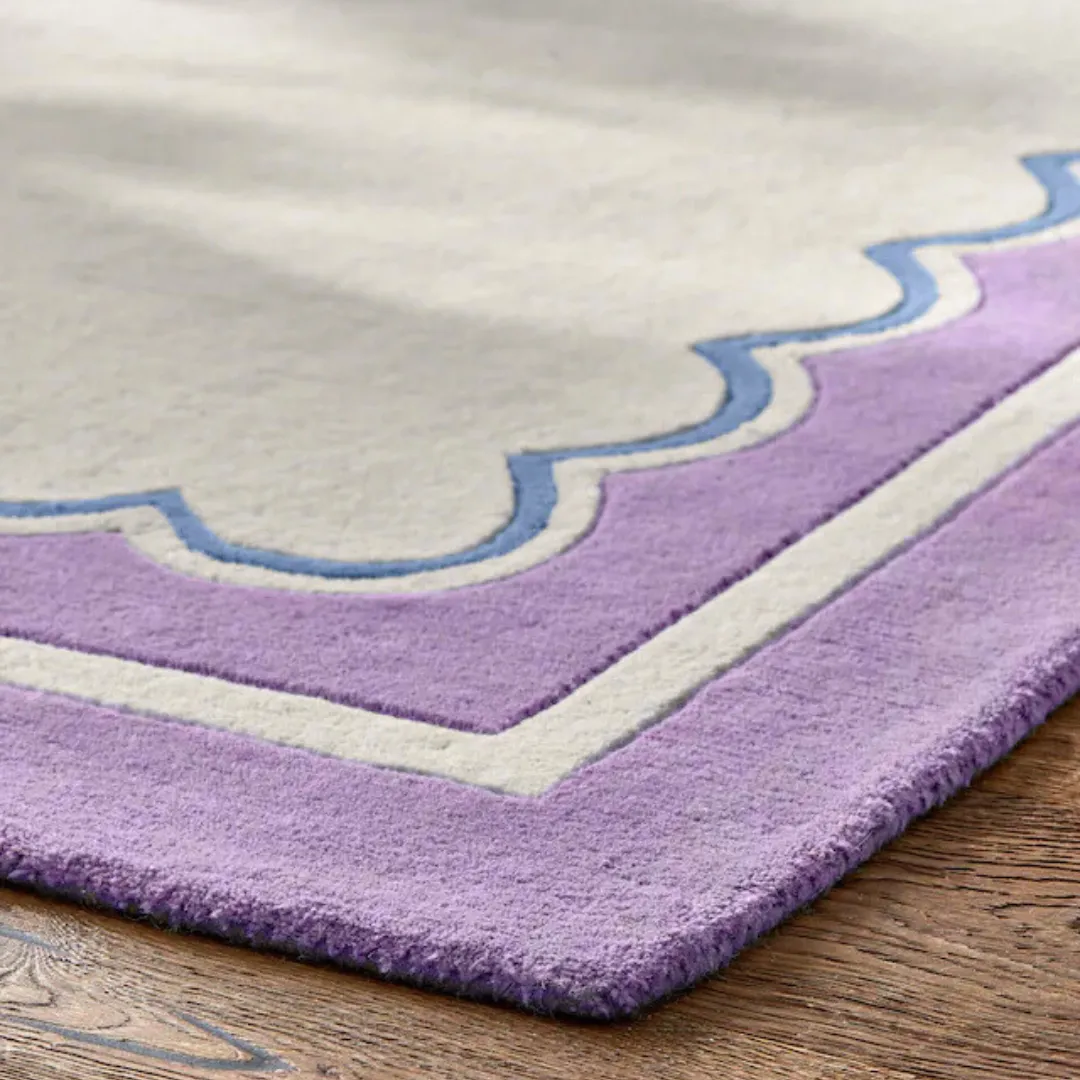 Close-up of purple border and scalloped design on hand tufted rug