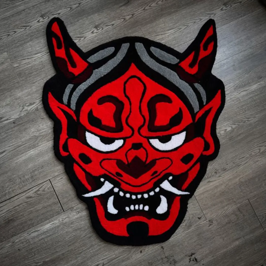 Red hand tufted Oni mask rug with bold black outlines, horns.