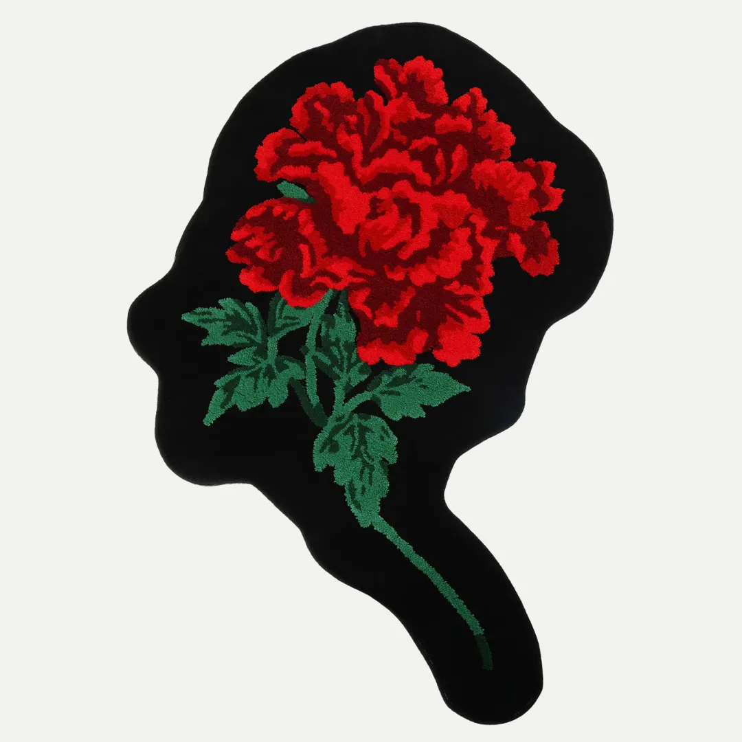 Black floral rug in the shape of a head silhouette with red blooming flower and green leaves, hand-tufted for bold and thoughtful decor
