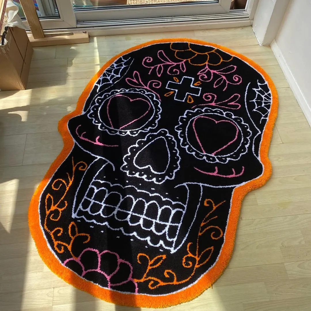 Sugar skull rug with black base and colorful orange, pink, and white floral details on a light wood floor.