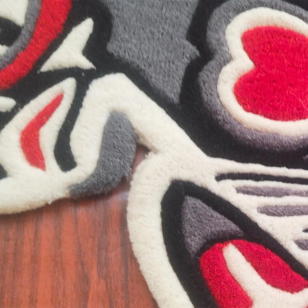 Tufted tribal bird rug with red heart, star shapes, and bold black and grey outlines inspired by tattoo and cultural art