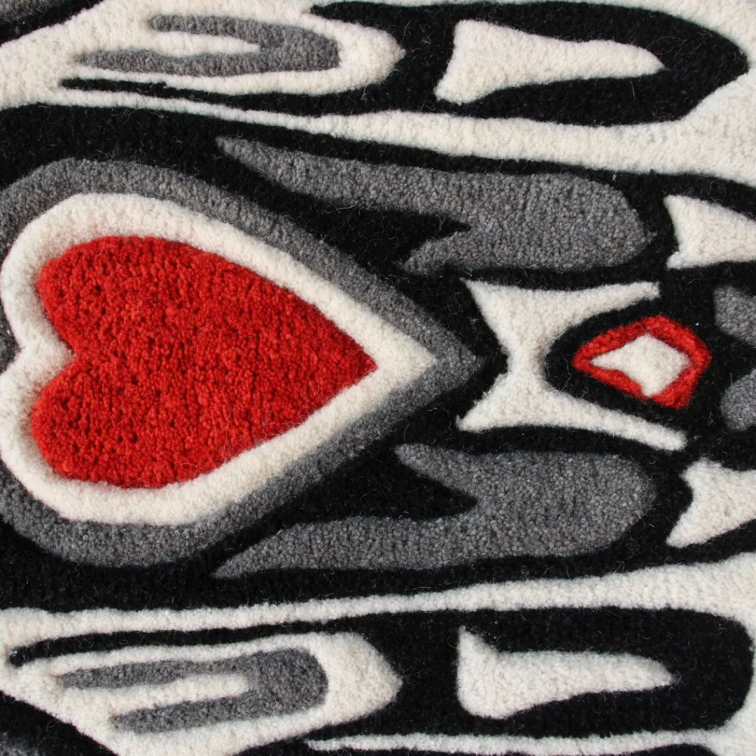 Handmade tribal bird rug with red heart, star shapes, and bold black and grey outlines inspired by tattoo and cultural art