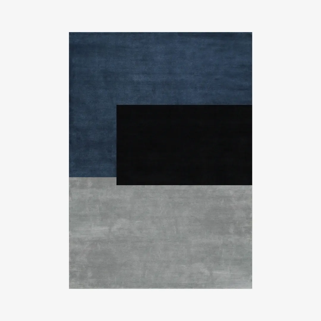 Modern geometric area rug with large blocks in black, blue, and gray