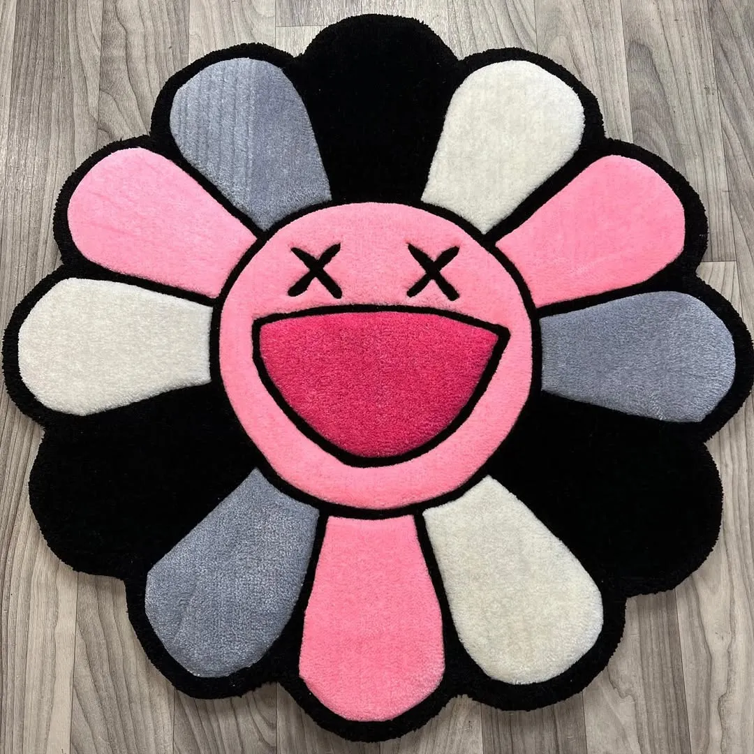 Petal Pop Rug Petal Pop Rug – Hand-tufted wool rug featuring pink, white, grey, and black petals with a playful smiling face design.