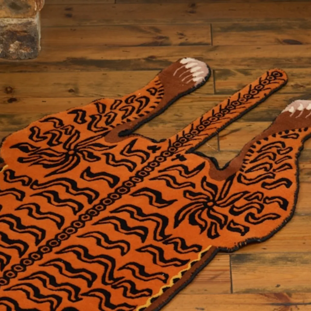 amber raja rug texture detail tail stripes Close-up detail of the rear section of the Amber Raja rug, showing the hand-tufted texture of the tiger's tail and hind legs with stylized claw details.