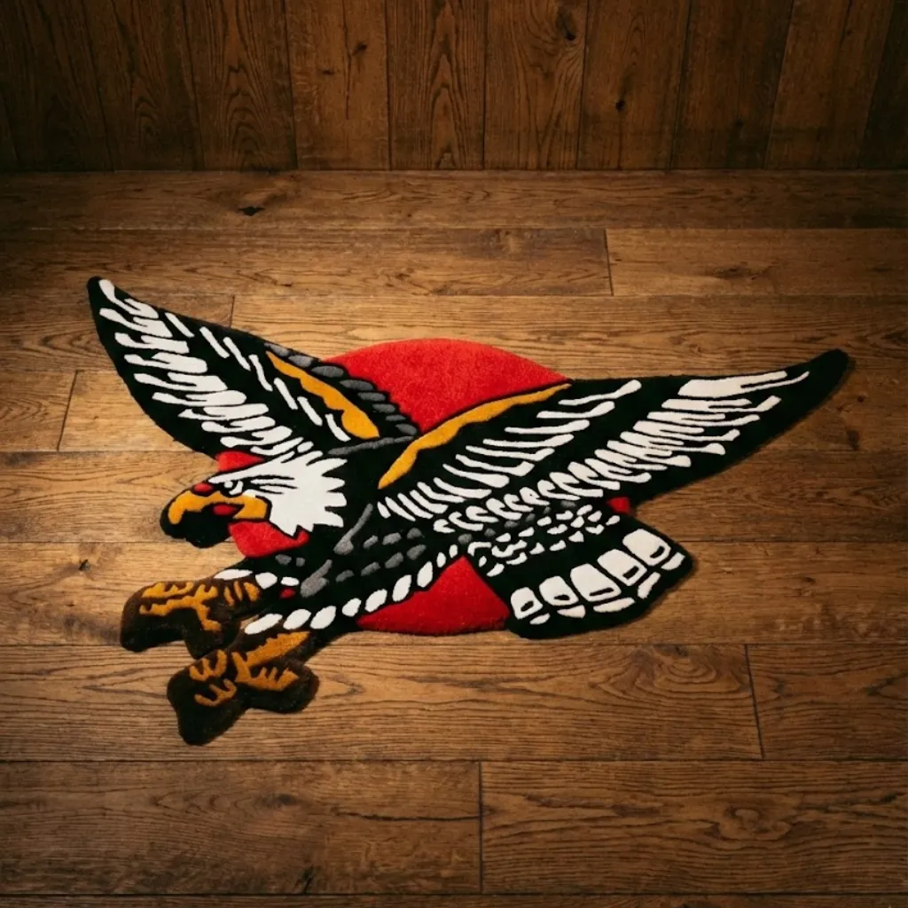 American Eagle Tattoo Style Hand Tufted Rug Top down view of a shaped wool rug featuring a classic American traditional tattoo design of a bald eagle in flight with a red circle background on a wooden floor.