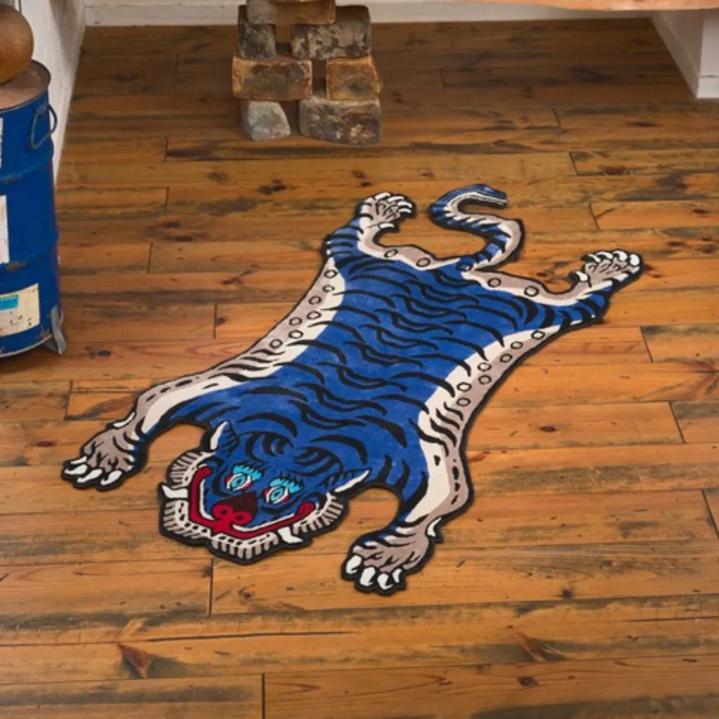 cobalt fang blue tiger skin shaped rug wood floor High angle view of the full Cobalt Fang rug placed on a rustic wooden floor, showcasing the traditional Tibetan tiger skin shape re-imagined in a bold blue and white colorway.