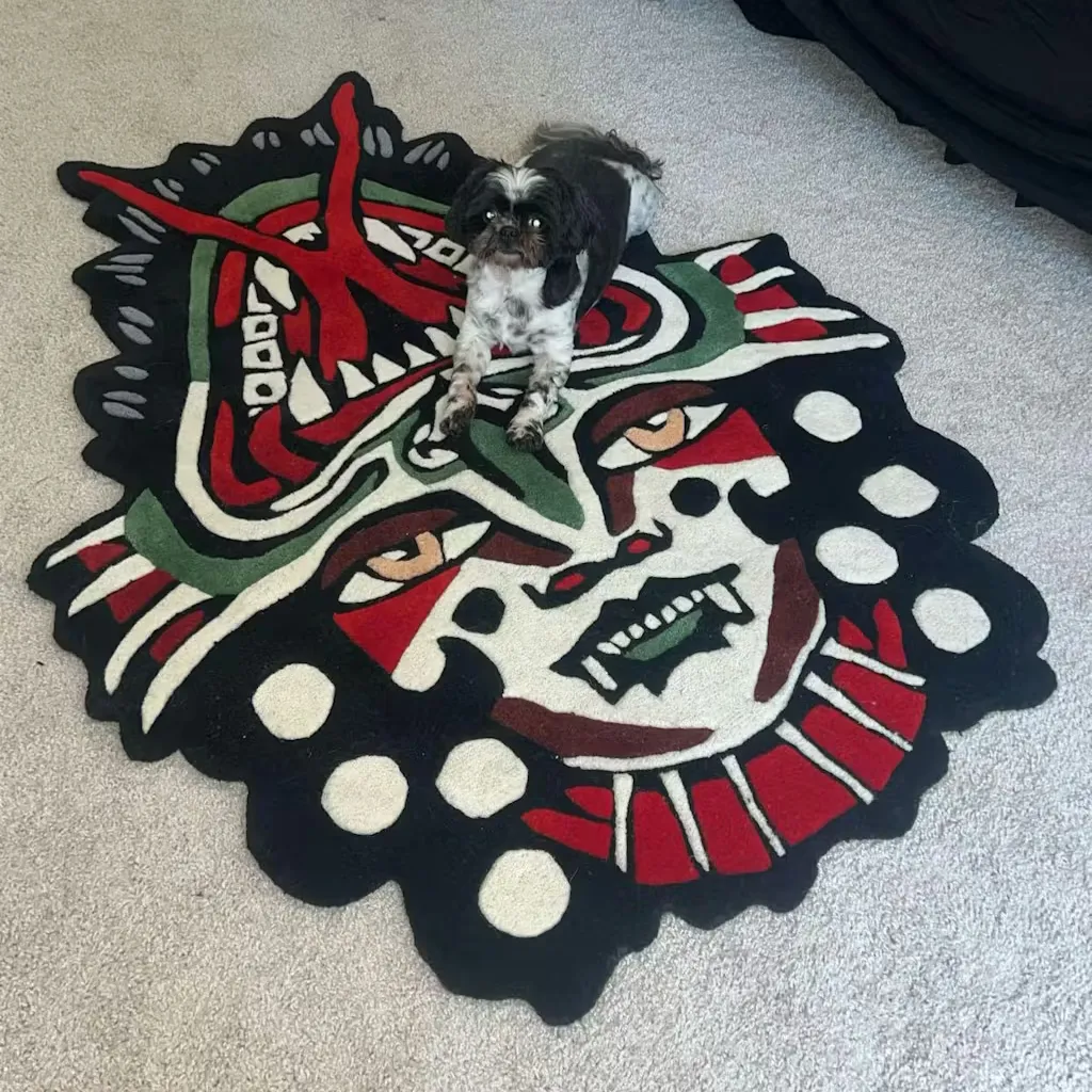 flip face rug lifestyle with dog Angled shot of the Flip Face hand tufted rug on a floor, showcasing the bold graphic lines and the unique custom shape inspired by vintage tattoo flash art.