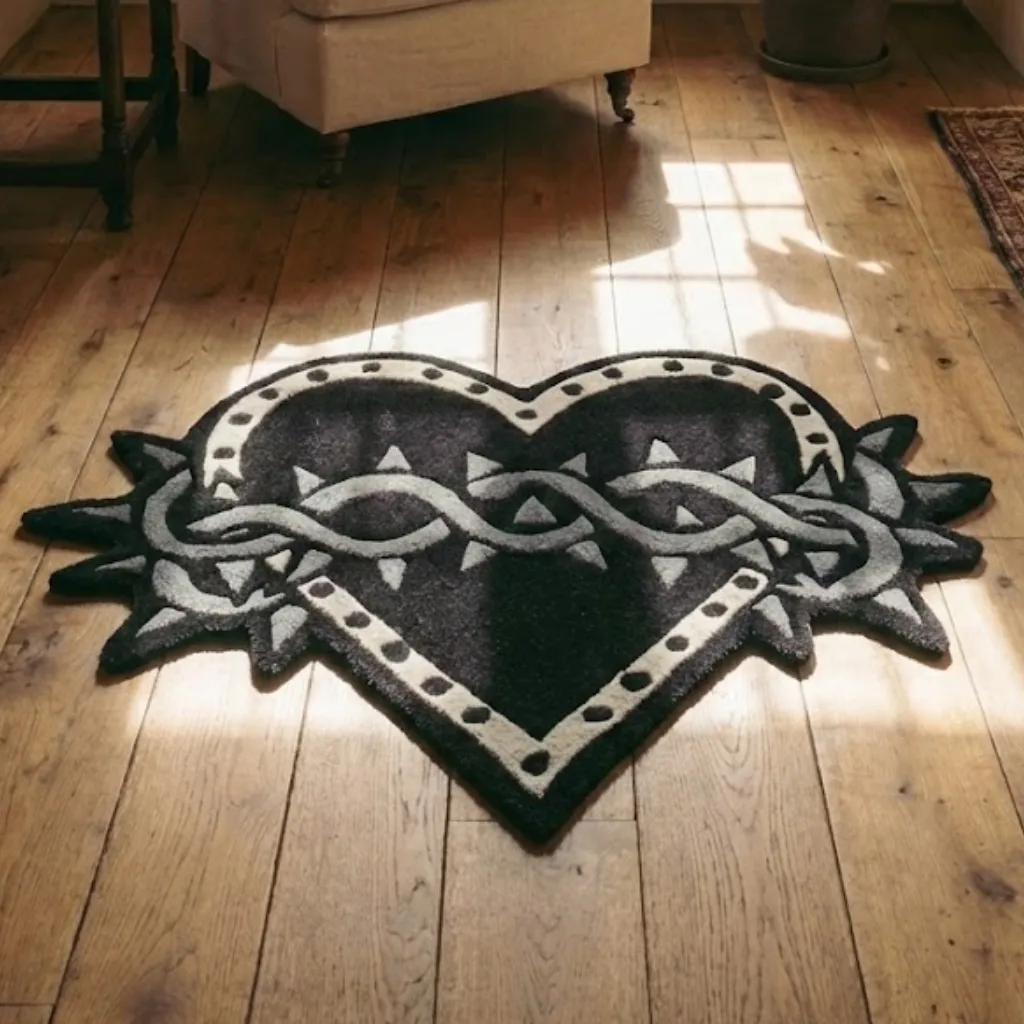 Gothic Barbed Wire Heart Shaped Rug Angled view of the Thorned Heart shaped rug placed on a wooden floor, highlighting the dense hand tufted wool texture and edgy gothic design elements.