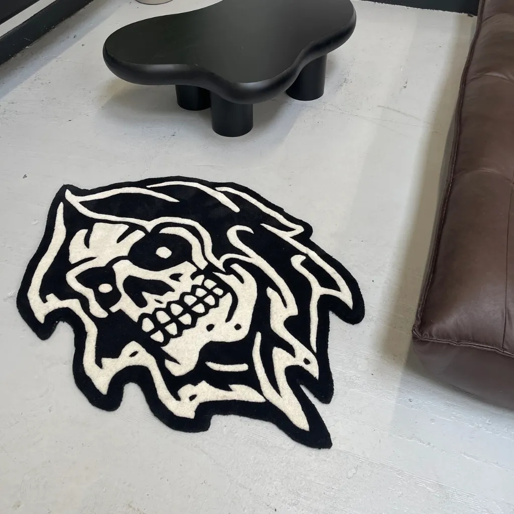 Grim Reaper American Traditional Tattoo Rug High angle view of the Grim Reaper American rug placed on a light grey floor, showing the custom die cut shape and monochromatic aesthetic next to modern furniture.
