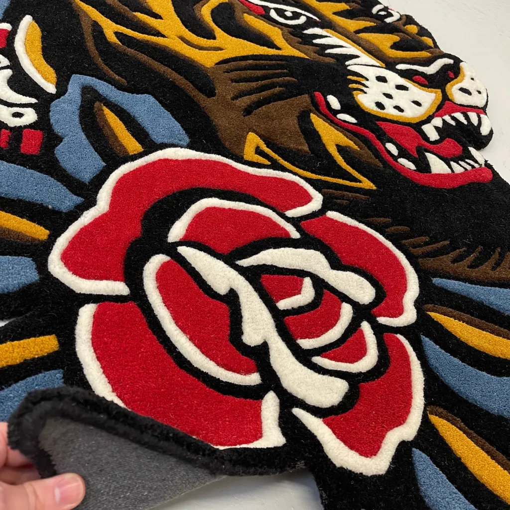 Hand Tufted Tiger Flash Art Floor Rug High angle view of the traditional tattoo style tiger rug placed on a dark wooden floor, adding a bold vintage aesthetic and pop of color to the room.
