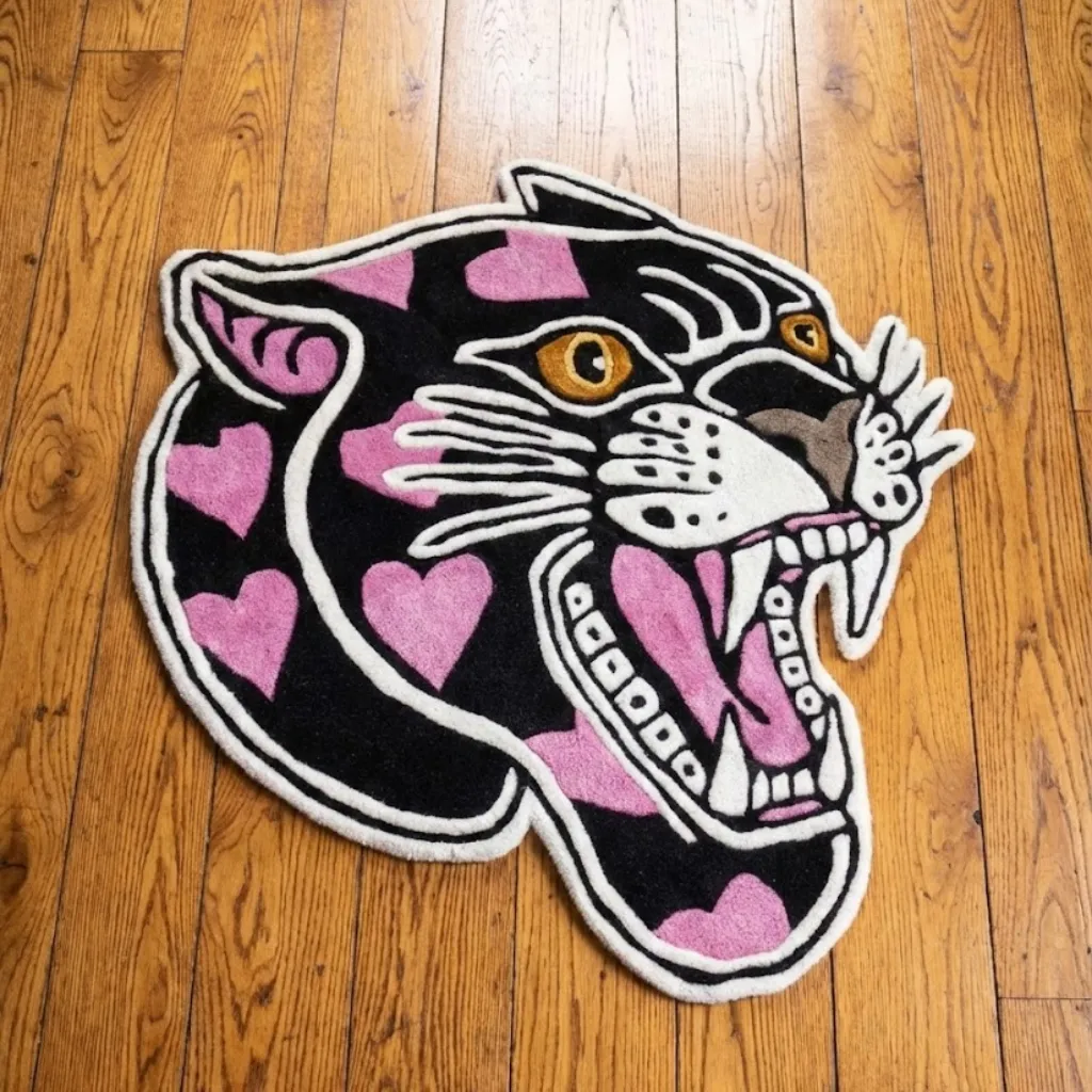 Pink Panther Head American Traditional Tattoo Rug Top down view of a hand tufted rug shaped like a roaring black panther head filled with pink hearts, featuring a classic American traditional tattoo design.