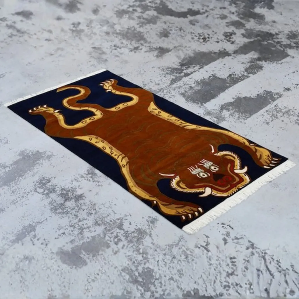 rooted fang hand tufted wool green tiger rug design Angled view of the Rooted Fang rug, highlighting the dense hand-tufted wool texture and the wandering black stripe pattern on a rich botanical green field.