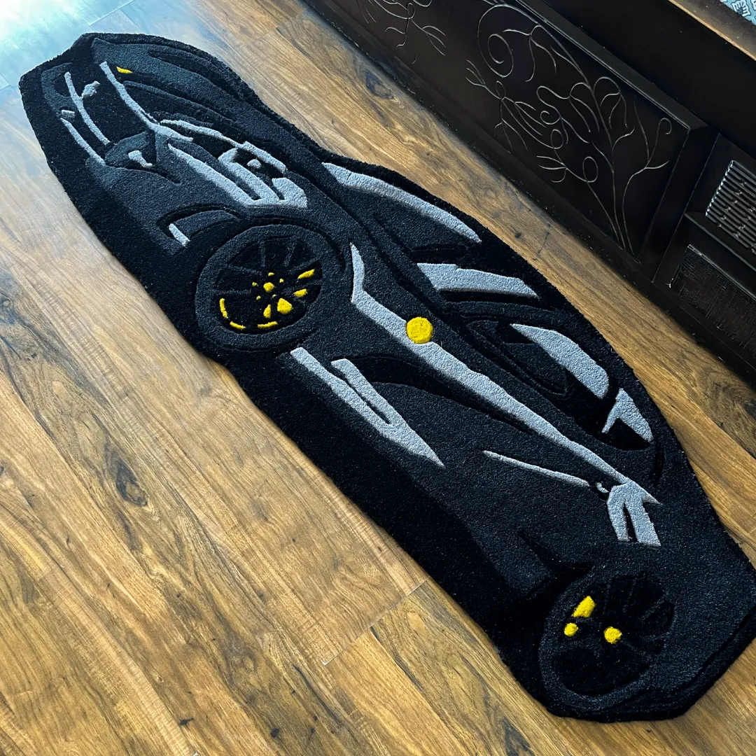 shadow monarch rug black car shaped decor Perspective view of the Shadow Monarch rug placed on a wooden floor, highlighting the plush tufted texture and the bold black and grey supercar design.