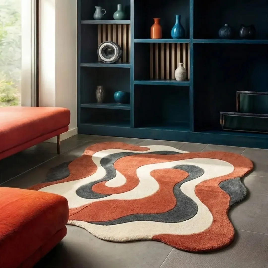 cavaro flow rug lifestyle Perspective lifestyle view of the Cavaro Flow rug placed on a grey tile floor, styled next to a burnt orange velvet bench to highlight its unique wavy border and retro-inspired fluid design.