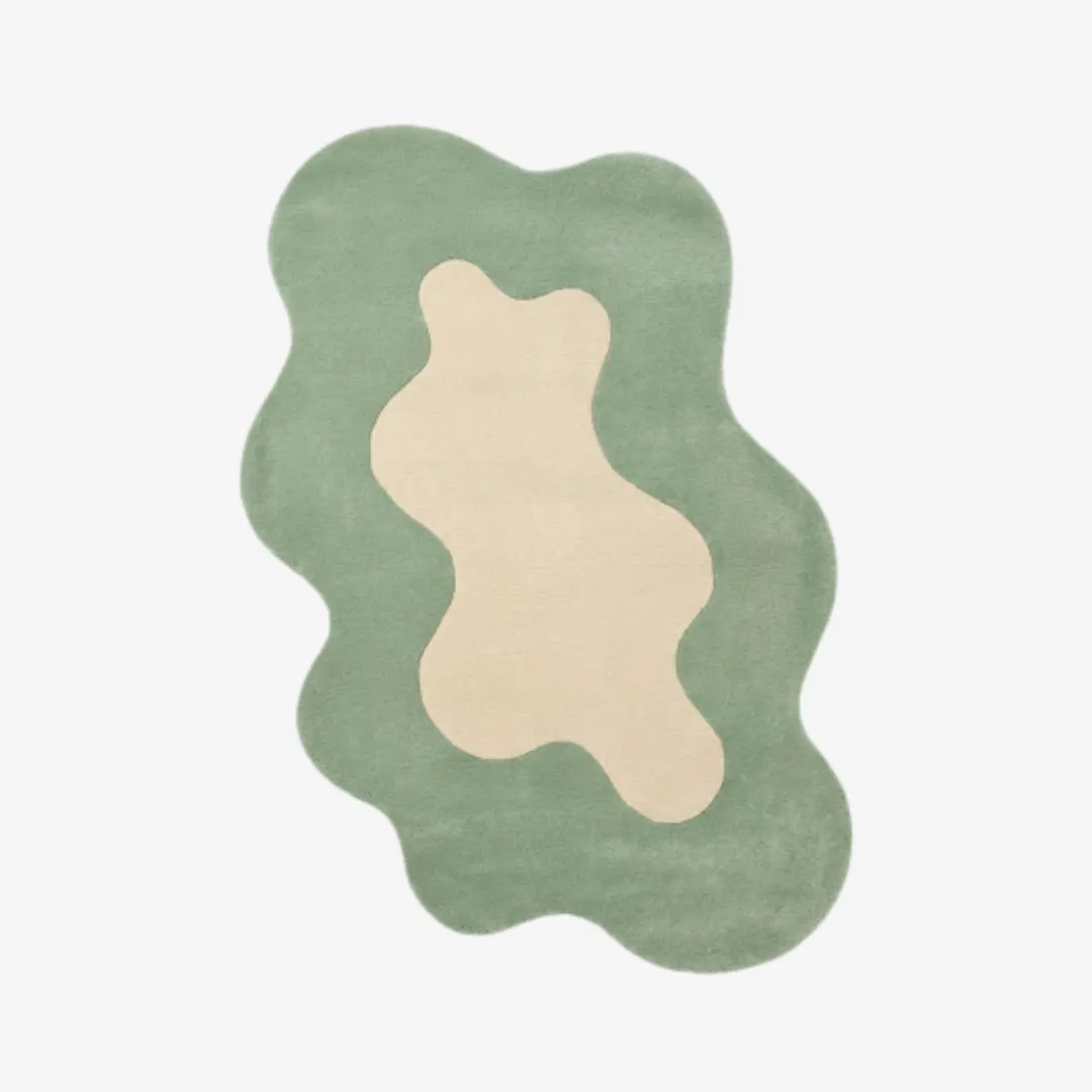 liom mist rug top Top-down view of the Liom Mist rug featuring a fluid, organic wavy silhouette and a soft sage green border surrounding a central cream-colored abstract shape.