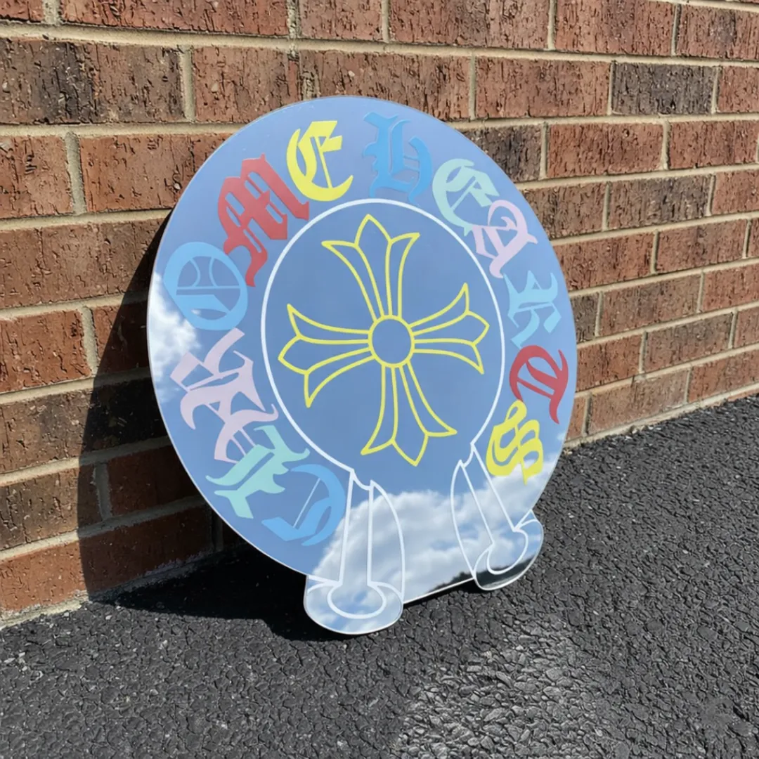 modern gothic cross acrylic mirror brick wall Modern gothic cross acrylic mirror with colorful lettering leaning against brick wall outdoor setting