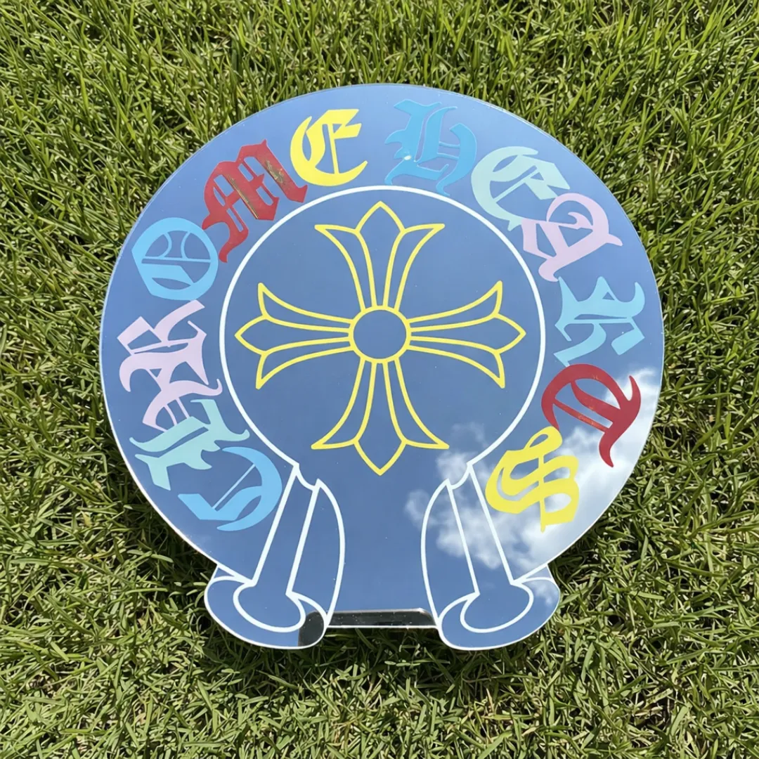 modern gothic cross mirror grass flat lay Round modern gothic cross mirror with multicolor typography placed on grass flat lay outdoor decor