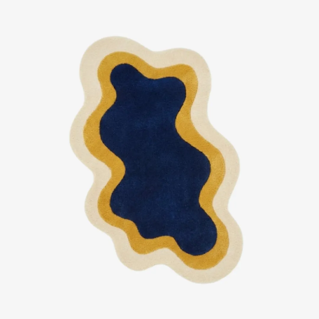 noctail glow rug top Top-down view of the Noctail Glow rug featuring a fluid, organic wavy silhouette with concentric nested layers of deep navy blue, golden yellow, and cream.