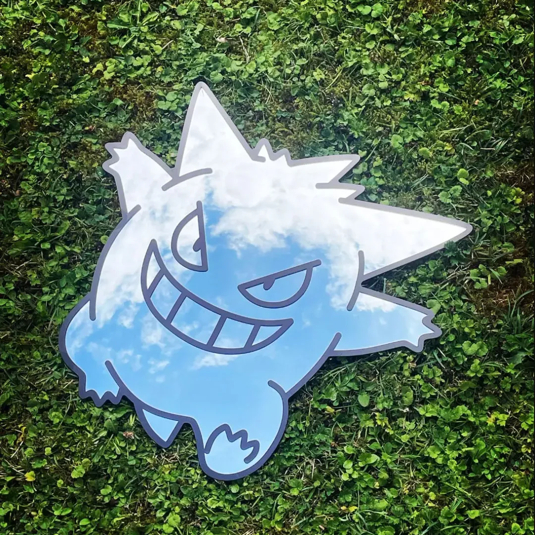 spooky ghost mirror front view white Straight-on view of the round Spooky Ghost Mirror resting on a white surface against a plain wall, featuring the white ghost decal and reflecting a modern light fixture.