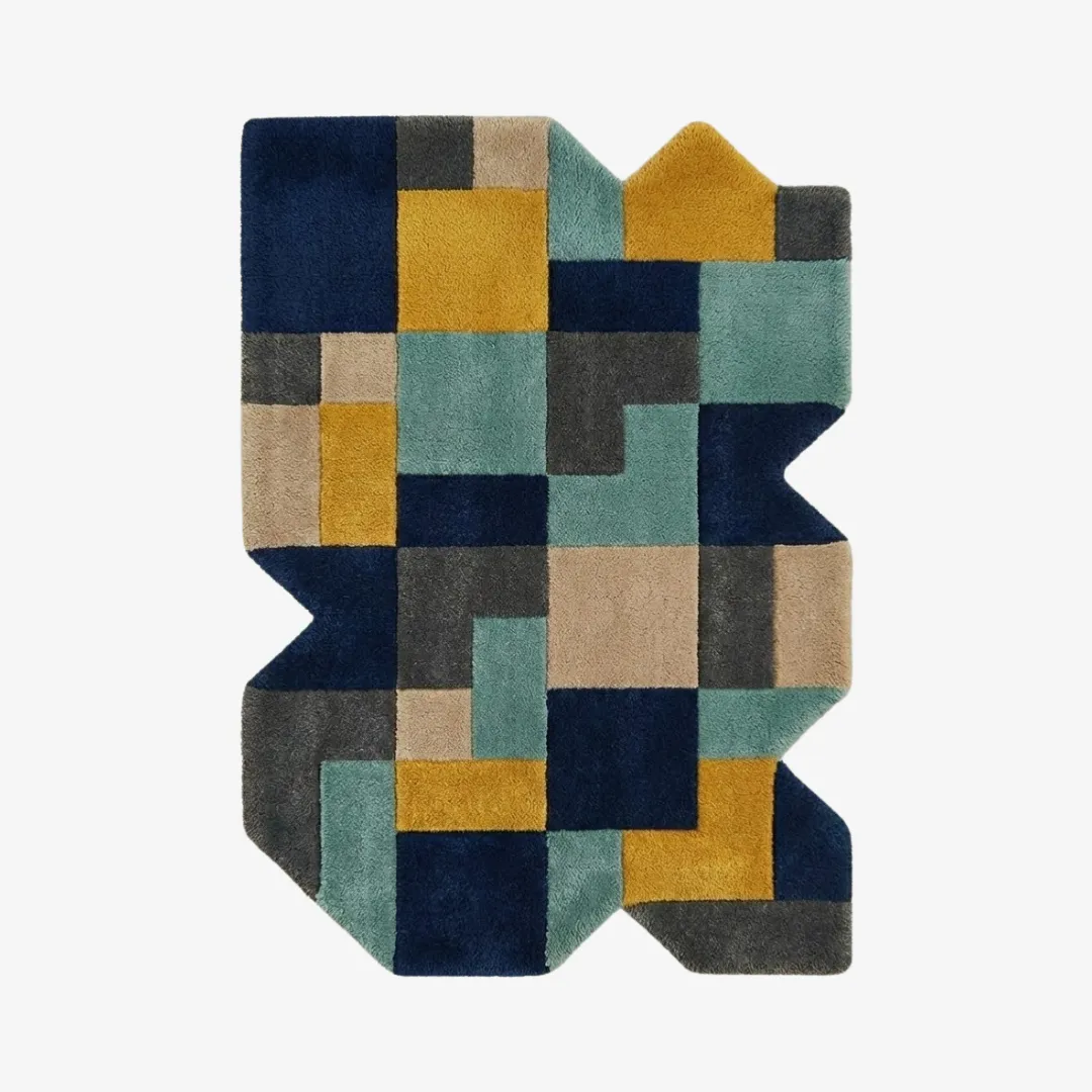 urban relic rug top Top-down view of the Urban Relic rug featuring a complex, jagged irregular silhouette and a dense geometric patchwork of navy blue, teal, mustard yellow, and charcoal grey blocks.