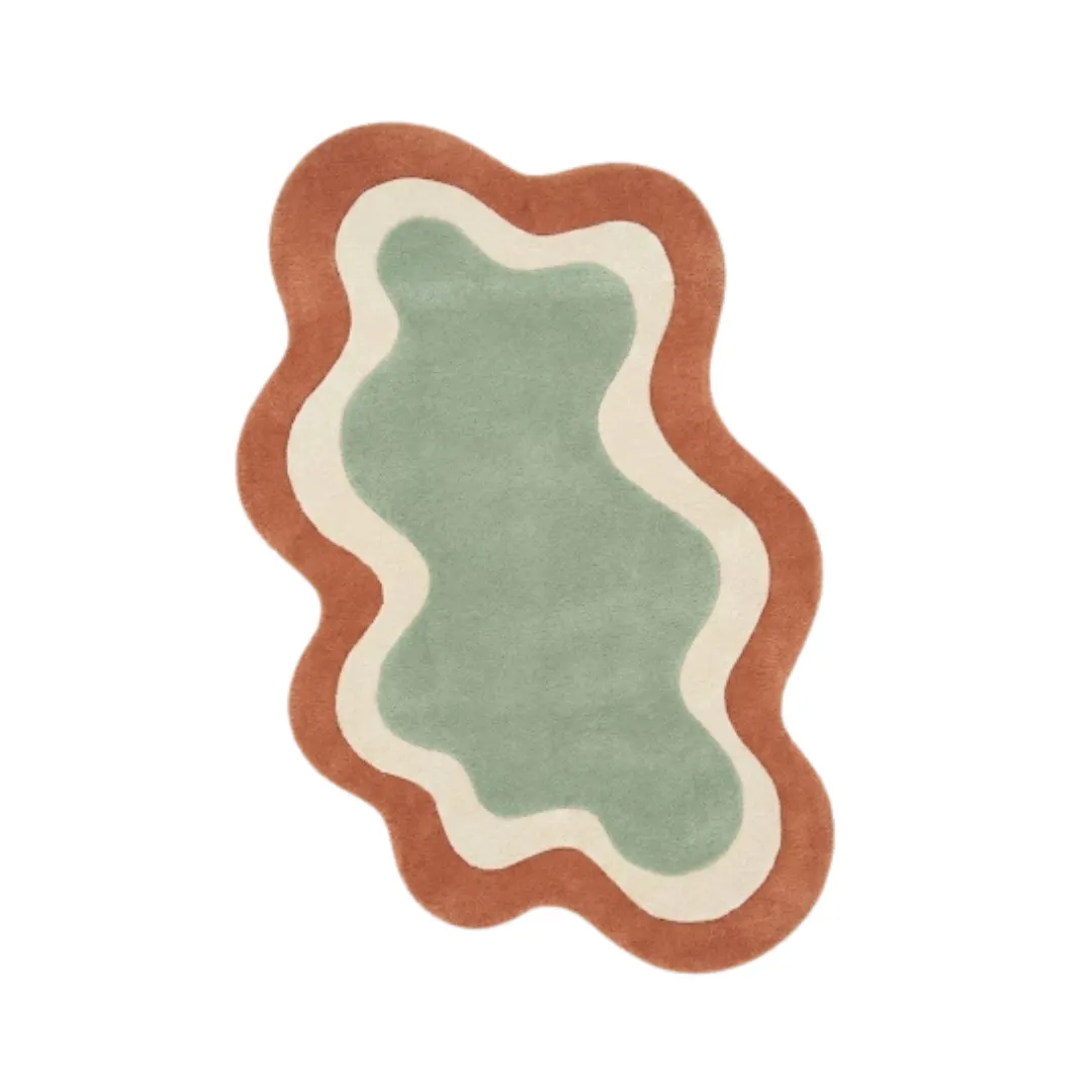 wellonest rug top Top-down view of the Wellonest rug featuring a fluid, organic wavy silhouette with nested layers of sage green, ivory, and terracotta orange.