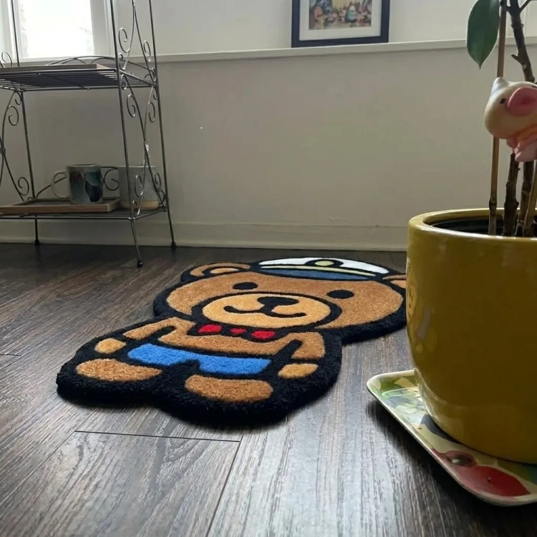 harbour line captain shaped area rug interior perspective An angled perspective shot of a hand-tufted captain bear rug, highlighting its playful silhouette and high-quality tufted wool texture on a wooden floor.