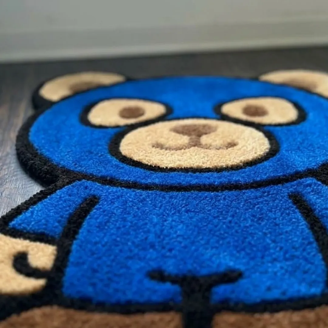 liberty shield shaped area rug texture close up A macro close-up of the liberty shield rug, focusing on the dense, tufted wool pile and the detailed blue and brown color blocking of the character design.