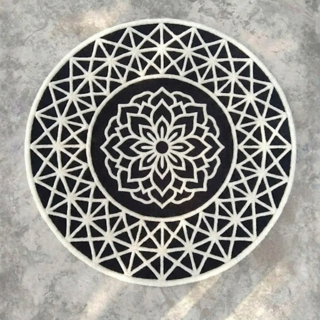 midnight noir crest round rug product shot Full top-down view of the circular black and white Midnight Noir Crest hand-tufted rug displayed on a concrete surface.