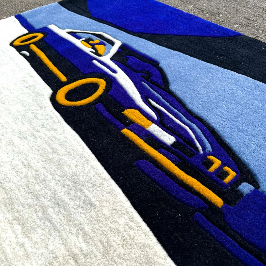 noctra veil rug texture Angled close-up view of the Noctra Veil rug placed on a concrete surface, emphasizing the dense wool texture and the clean lines separating the car's bright yellow wheels from the white lower body.