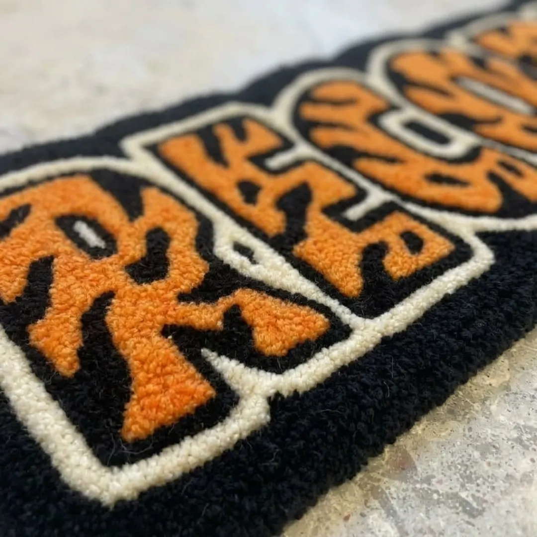 orange record rug texture close up Close-up macro photograph highlighting the thick wool material texture and clean lines of the Orange Record Rug.