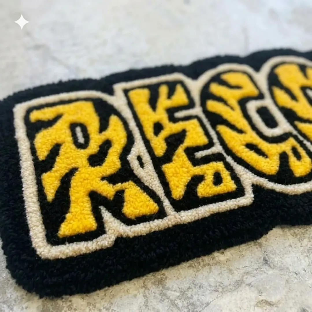 record rug texture close up Close-up macro photograph highlighting the thick material texture and clean letter outlines of the yellow Record Rug.