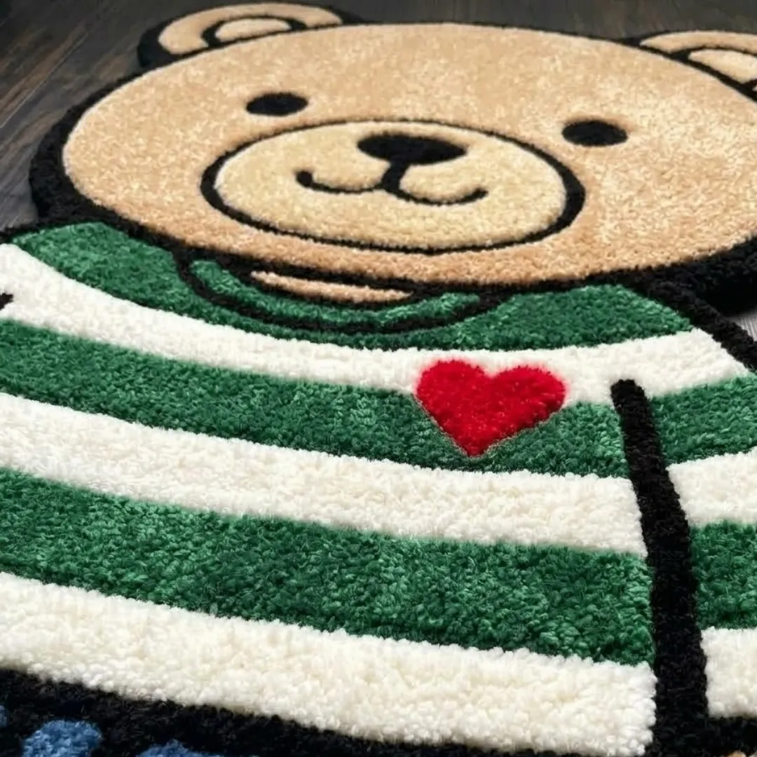 stormbound ape shaped area rug texture close up A macro close-up of the stormbound ape rug, focusing on the dense, tufted wool pile and the detailed green-and-white striped sweater and red heart motif.